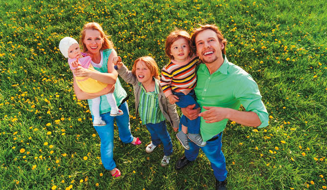 Smiling family portrait from above in park in summer